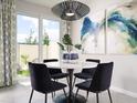 Bright dining area featuring modern light fixture, marble table, patio access, and stylish decor at 16395 Bird Of Paradise Ave, Clermont, FL 34714