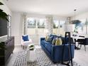 Inviting living room with blue sofa, stylish rug, designer accents, and plenty of natural light at 16395 Bird Of Paradise Ave, Clermont, FL 34714