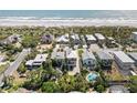 A coastal community is showcased in this aerial view, with a sandy beach along the ocean and homes surrounded by lush vegetation at 1640 N Atlantic Ave, New Smyrna Beach, FL 32169