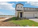 Two-story townhouse with an attached garage, a covered entry, and a well-maintained lawn at 1805 Archer Dr, Minneola, FL 34715