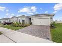 Well maintained home boasts a brick paver driveway and manicured landscaping at 2003 Spring Shower Cir, Kissimmee, FL 34744