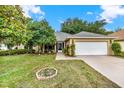 Inviting home with a well-maintained lawn, mature trees, and a two-car garage providing curb appeal at 26807 Bull Run, Leesburg, FL 34748