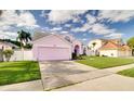 Charming pink two-story home with a well-manicured lawn and a two-car garage at 2712 Rolling Broak Dr, Orlando, FL 32837