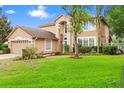 Charming two-story home with a spacious front yard, beautiful landscaping, and a neutral-toned exterior at 3468 Woodley Park Pl, Oviedo, FL 32765
