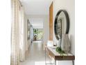 Bright, airy hallway with tile floors, decorative mirror, and art piece for a welcoming atmosphere at 3641 Fort Mellon Ln, Sanford, FL 32773