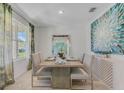 Elegant dining room with a modern table, plush seating, and large windows for natural light at 3846 Royal Azalea Way, Sanford, FL 32773