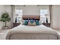 Bedroom with stylish headboard, decorative pillows and ample natural light from two windows at 3850 Royal Azalea Way, Sanford, FL 32773