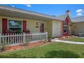 Inviting covered front porch with chairs and a charming white picket fence at 5583 Miles Dr, Port Orange, FL 32127