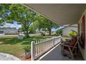 Covered front porch with seating area and view of the well-maintained front yard at 5583 Miles Dr, Port Orange, FL 32127