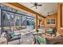 Comfortable covered patio featuring a seating area, outdoor kitchen, and views of the screened-in pool at 605 W Palm Valley Dr, Oviedo, FL 32765