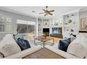 Cozy living room features a fireplace, white built-ins, comfortable sofas, and views of the outdoor pool at 605 W Palm Valley Dr, Oviedo, FL 32765