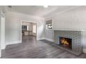 Cozy living room features a brick fireplace, neutral paint and gray wood floors at 735 N Clara Ave, Deland, FL 32720
