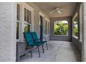 Relaxing covered porch features gray textured walls, tile floor, and ceiling fan at 735 N Clara Ave, Deland, FL 32720