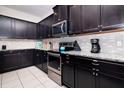 Modern kitchen featuring granite countertops, stainless steel appliances, and dark cabinetry at 8924 Bengal Ct, Kissimmee, FL 34747