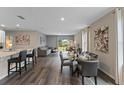 Open-concept living room featuring hard wood floors, dining table, and comfortable seating area at 984 Commons Way, Port Orange, FL 32129