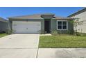 Charming single-story home featuring a two-car garage and well-maintained front lawn at 1596 Park Side Ave, Kissimmee, FL 34744