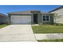 Charming single-story home featuring a two-car garage and well-maintained front lawn at 1596 Park Side Ave, Kissimmee, FL 34744
