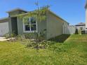 A cozy home featuring green grass, a white privacy fence, and some low-profile landscaping at 1596 Park Side Ave, Kissimmee, FL 34744