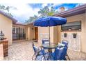 Cozy outdoor patio featuring brick accents, a table, chairs, and blue umbrella at 103 Golf Club Dr, Longwood, FL 32779