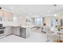 Bright, open-concept kitchen and living room with stainless steel appliances and modern lighting at 10915 Leafshore Loop, Orlando, FL 32829