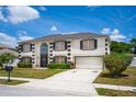 Inviting two-story home featuring a well-maintained lawn, a garage, and nice landscaping at 114 Shaddock Dr, Auburndale, FL 33823