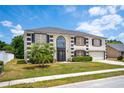 Attractive two-story home with lush landscaping, a well-maintained lawn, and a charming facade at 114 Shaddock Dr, Auburndale, FL 33823