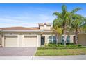 Inviting exterior showcasing a landscaped yard, well-maintained lawn, and two-car garage at 1161 Trappers Trail Loop, Davenport, FL 33896