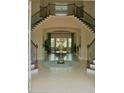 Elegant foyer featuring a grand staircase with decorative iron railings and a decorative table at 12030 Waterstone Loop Dr, Windermere, FL 34786