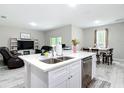 Open concept design featuring a kitchen island with double sinks, dishwasher, and seating in the main living space at 13297 Sw 69Th Pl, Ocala, FL 34481
