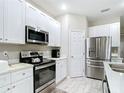 Modern kitchen with stainless steel appliances, sleek white cabinets, and stone countertops at 13297 Sw 69Th Pl, Ocala, FL 34481