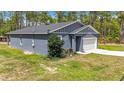 Side view of a well-maintained home featuring a 2-car garage and lush green lawn at 13297 Sw 69Th Pl, Ocala, FL 34481