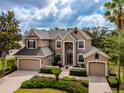 Elegant two-story home with a three-car garage, manicured landscaping and a paver driveway at 14003 Hampshire Bay Cir, Winter Garden, FL 34787