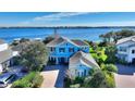 Stunning two-story home with beautiful blue facade and landscaped front yard overlooking the water at 14906 Speer Lake Dr, Winter Garden, FL 34787