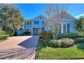 Beautifully landscaped front yard with brick paver driveway leading to a charming two-story home at 14906 Speer Lake Dr, Winter Garden, FL 34787