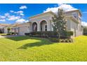 Charming single-story home with a manicured green lawn and an arched entryway with an American flag at 1780 Southern Red Oak Ct, Ocoee, FL 34761