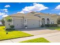 Charming single-story home with a three-car garage, brick paver driveway, and a manicured green lawn at 1780 Southern Red Oak Ct, Ocoee, FL 34761