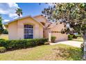 Single-story home with a well-manicured lawn, arched window, and attached two-car garage at 19756 Glen Elm Way, Orlando, FL 32833