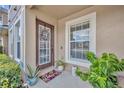 Inviting entryway featuring a wood front door, wreath, potted plants and a welcome mat at 212 Belvedere Way, Sanford, FL 32773