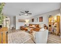 Bright living room with neutral walls, modern fan, stylish rug and comfortable leather couch at 212 Belvedere Way, Sanford, FL 32773