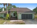Close up on single Gathering home with 2 car garage, stone accents, mature trees and grass yard at 21343 Reindeer Rd, Christmas, FL 32709