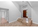 The tiled foyer features a decorative front door, stairway, and a hallway with doorways at 21343 Reindeer Rd, Christmas, FL 32709