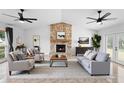 Bright living room features a stone fireplace, ceiling fans and ample seating, perfect for relaxing and entertaining at 21343 Reindeer Rd, Christmas, FL 32709