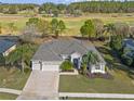 Picturesque home with well maintained landscaping, a brick driveway, and golf course views in the background at 23533 Valderama Ln, Sorrento, FL 32776
