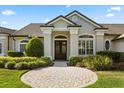 Elegant home featuring a beautiful brick walkway and manicured garden at 240 Promenade Cir, Lake Mary, FL 32746