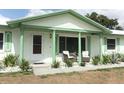 Inviting covered front porch with seating and meticulously landscaped yard at 3212 Acoma Dr, Orlando, FL 32829