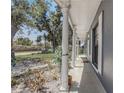 Inviting front porch view with white columns, beautiful trees, and a well-maintained lawn at 4201 Chantelle Rd, Orlando, FL 32808