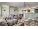 Comfortable living room with stylish wood-look flooring, modern furniture, and views to the kitchen and dining area at 4201 Chantelle Rd, Orlando, FL 32808