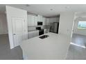 Modern kitchen with a large island, stainless steel appliances, and sleek white cabinetry at 4891 Lyric Dr, Mascotte, FL 34753