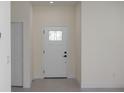 Bright foyer featuring a white front door with decorative glass and tile floors, adjacent to a white closet door at 714 Palmetto Ave, Orange City, FL 32763
