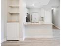 A bright, open kitchen featuring modern white cabinets, stainless steel appliances, and a breakfast bar with granite countertops at 8908 Legacy Ct # 303, Kissimmee, FL 34747